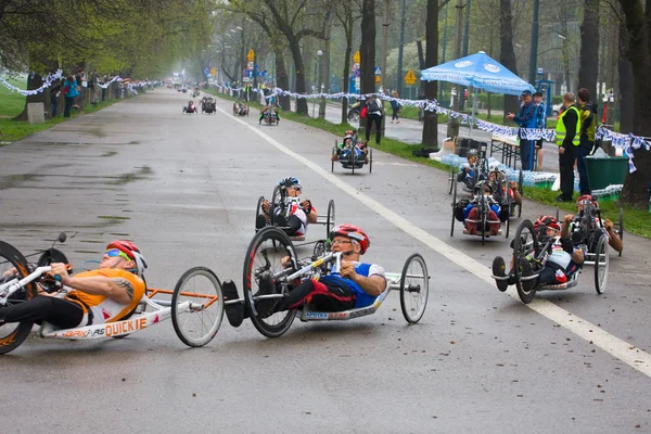 KRAKOW, POLAND - APRIL 28 : Cracovia Marathon.Handicapped man marathon runners in a wheelchair on the city streets on April 28, 2013 in Krakow, POLAND — Stock Photo, Image