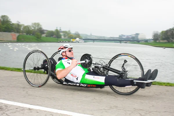 KRAKOW, POLAND - APRIL 28 : Cracovia Marathon.Handicapped man marathon runners in a wheelchair on the city streets on April 28, 2013 in Krakow, POLAND — Stock Photo, Image