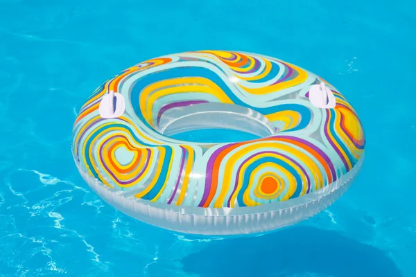 Colorful inflatable ball and round tube floating in swimming pool — Stock Photo, Image