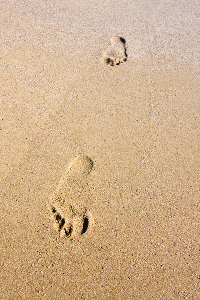 Voetstappen op zonsondergang tijd op het strand — Stockfoto