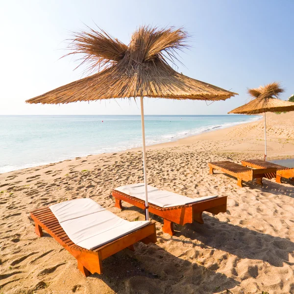 Ombrelloni sulla spiaggia di sabbia bianca con cielo azzurro nuvoloso e sole — Foto Stock