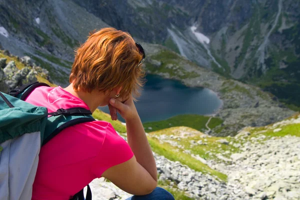 Vrouw zitten op de bergtop en het bewonderen van berglandschap — Stockfoto