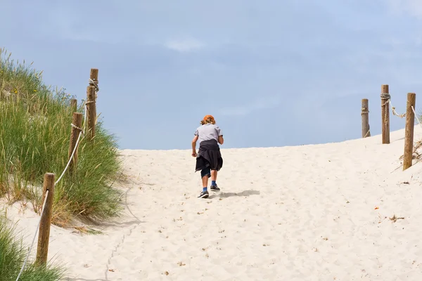 Rapaz solitário a caminhar através de uma duna de areia — Fotografia de Stock