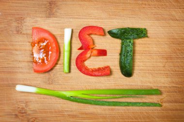 ahşap arka plan üzerinde kesme tahtası ve kelime diyet sebze