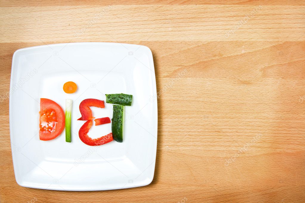 Plate with vegetables and word diet over wooden background