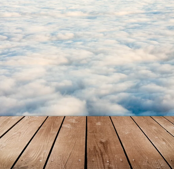 Lege houten dek tafel met wolken. Ready, voor product montage weergave. — Stockfoto