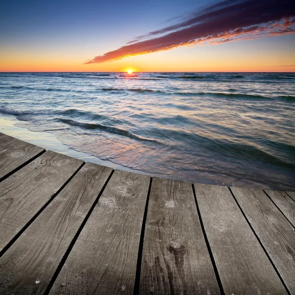 Pôr do sol e mesa de deck de madeira vazia . — Fotografia de Stock
