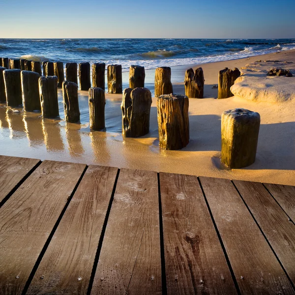 Pôr do sol na praia e mesa de deck de madeira vazia . — Fotografia de Stock