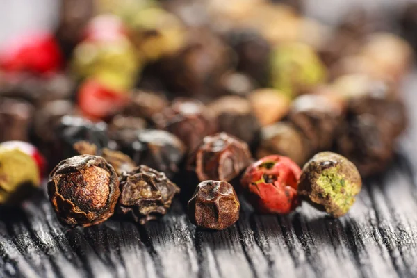 Pepper corns on a wooden board — Stock Photo, Image