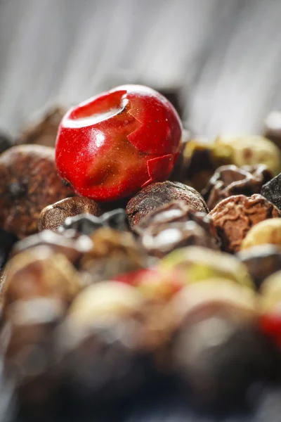 Pepper corns on a wooden board — Stock Photo, Image