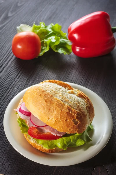 Sándwich de jamón rebanado con tomates en una mezcla de pan de semilla — Foto de Stock