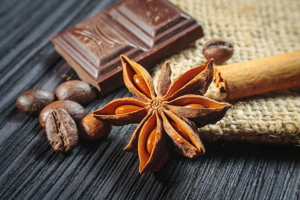 Barra de chocolate y especias en mesa de madera —  Fotos de Stock