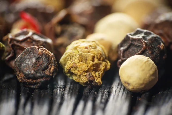 Pepper corns on a wooden board — Stock Photo, Image