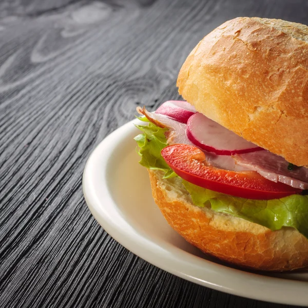 Deliciosas baguettes de jamón con lechuga fresca y pimentón en una mesa de cocina de madera vieja — Foto de Stock