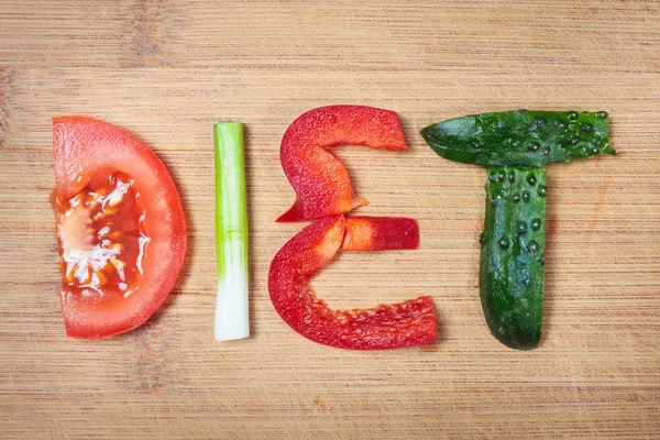 Assiette avec légumes et régime alimentaire mot sur fond en bois — Photo