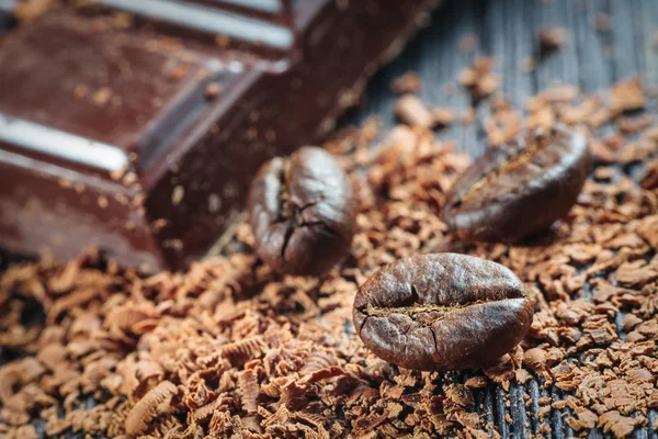 Frisch geröstete Kaffeebohnen und ein Stapel brauner Schokolade — Stockfoto