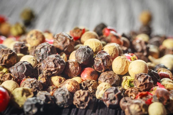 Pepper corns on a wooden board — Stock Photo, Image