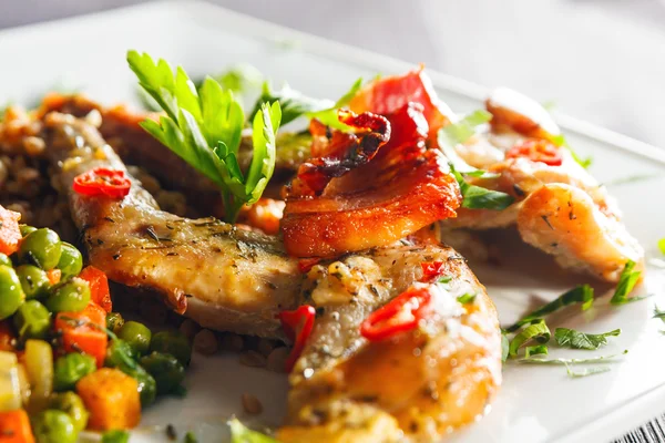 Ofen gebackene Hasenkeulen mit grünen Erbsen und Karotten — Stockfoto