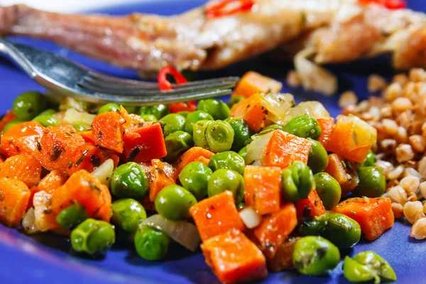 Ofen gebackene Hasenkeulen mit grünen Erbsen und Karotten — Stockfoto