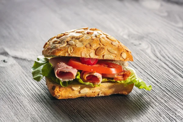 Um sanduíche fresco com presunto, rabanete, tomate — Fotografia de Stock