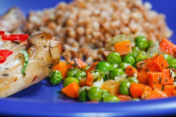 Oven baked rabbit legs with green peas and carrot Stock Picture