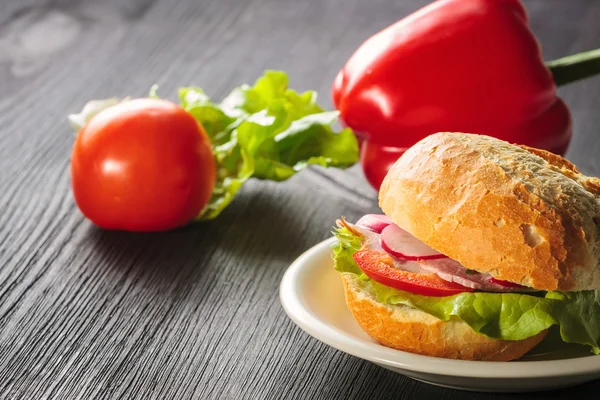 Sándwich de jamón rebanado con tomates en una mezcla de pan de semilla — Foto de Stock