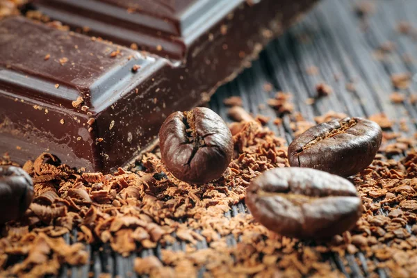 Chicchi di caffè torrefatto fresco e pila di cioccolato marrone — Foto Stock