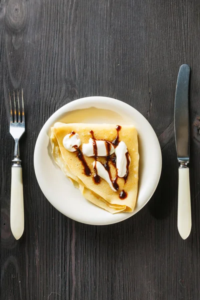 Closeup of chocolate pancakes with whipped cream — Stock Photo, Image