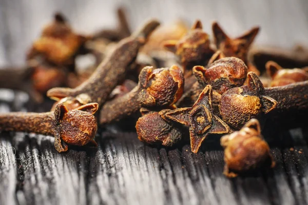 Pile cloves on wood background — Stock Photo, Image