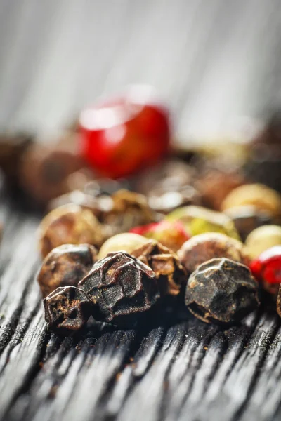 Pepper corns on a wooden board — Stock Photo, Image