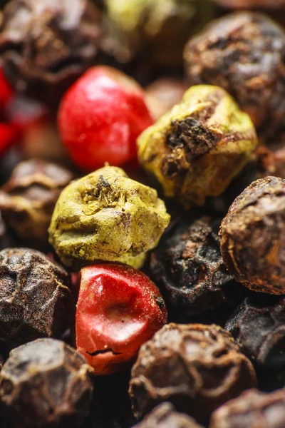 Pepper corns on a wooden board — Stock Photo, Image