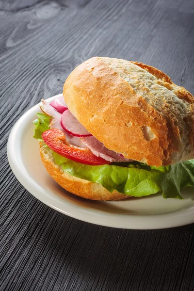 Delicious ham baguettes with fresh lettuce and paprika on an old wooden kitchen table top — Stock Photo, Image