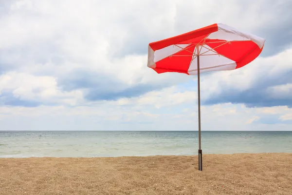 Bulutlu mavi gökyüzü ile sahilde plaj şemsiyeleri — Stok fotoğraf