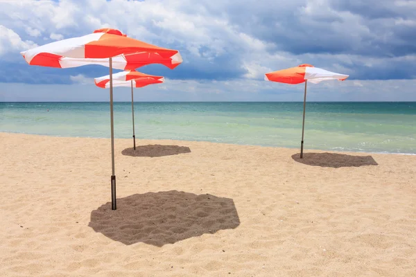 Sonnenschirme am Strand mit wolkenlosem blauen Himmel — Stockfoto