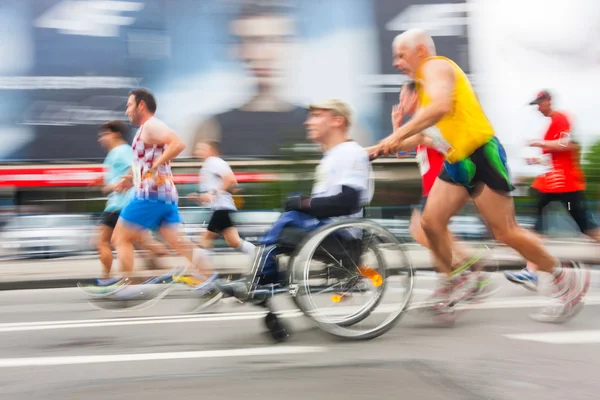 KRAKOW, POLONIA - 28 de mayo: Maratón de Cracovia. Hombre discapacitado no identificado en maratón en silla de ruedas en las calles de la ciudad el 18 de mayo de 2014 en Cracovia, POLONIA —  Fotos de Stock