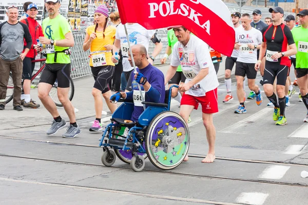 KRAKOW, POLAND - MAY 28 : Cracovia Marathon. Uidentifisert handikappet mann i maraton på en rullestol i byens gater 18. mai 2014 i Krakow, POLAND – stockfoto