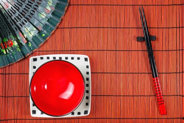 Dwie pałeczki na tle Mata sushi — Zdjęcie stockowe