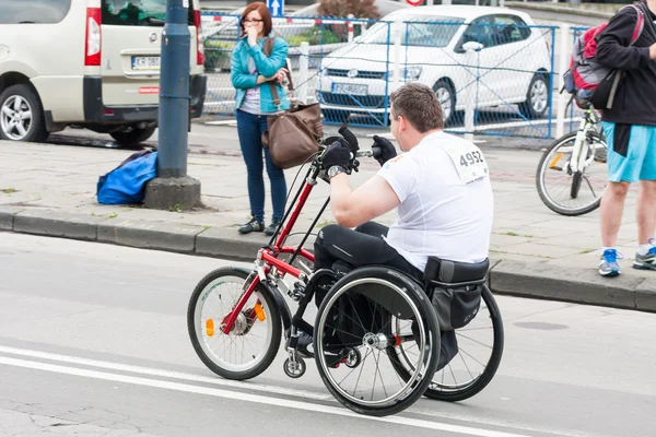 KRAKOW, POLONIA - 28 de mayo: Maratón de Cracovia. Hombre discapacitado no identificado en maratón en silla de ruedas en las calles de la ciudad el 18 de mayo de 2014 en Cracovia, POLONIA — Foto de Stock