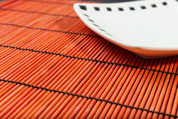 Plate on bamboo mat — Stock Photo, Image