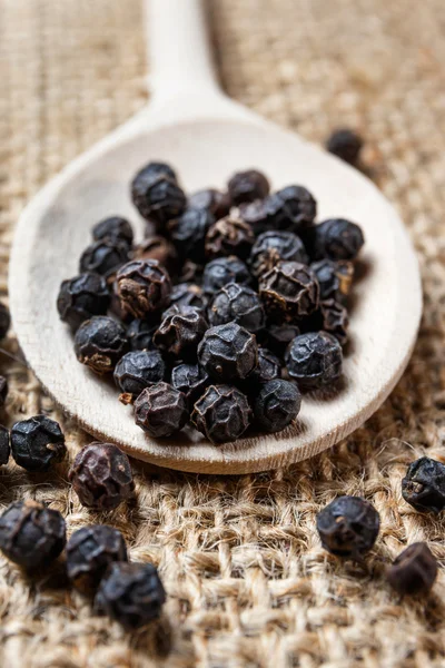 Black pepper on the wooden spoon — Stock Photo, Image