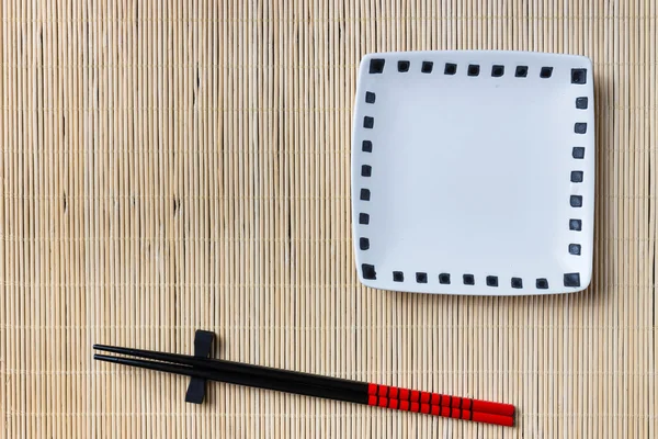 Two chopsticks on sushi mat background — Stock Photo, Image