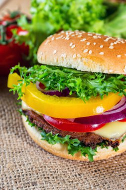 huisgemaakte hamburger met verse groenten op snijplank