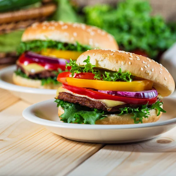 Hamburguesa casera con verduras frescas en la tabla de cortar — Foto de Stock