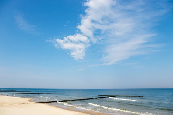 孤独な男がビーチを歩いて青い空の背景 — ストック写真