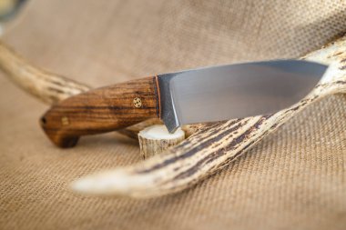 Kahverengi arka planda el yapımı avcı bıçağı.