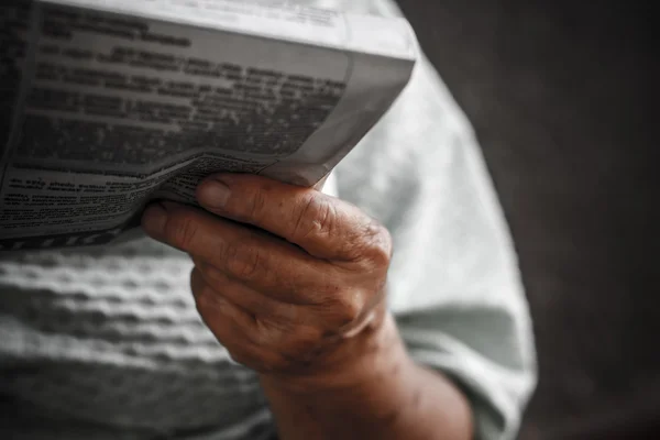 Periódico en la mano de una anciana (fuente rusa borrosa) ) Imagen De Stock