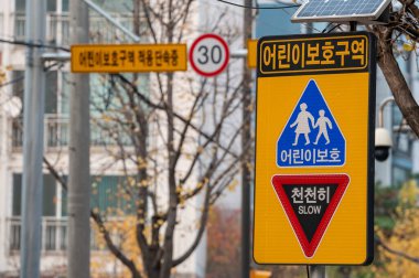 Okul alanı trafik levhası ve hız yapan arabaları kontrol eden kamera. Güney Kore.