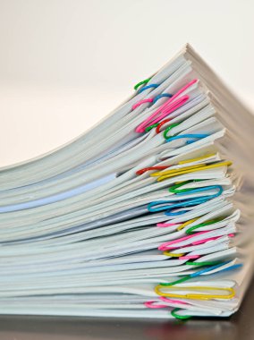 Masanın üzerine yığılmış yığınla belge..