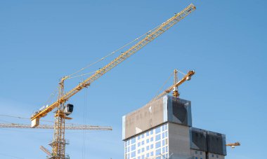 Gökyüzünde pek çok inşaat kulesi vinci olan bir panorama..