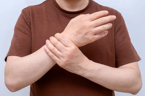 A man wrapped around his wrist because of wrist pain. Causes of rheumatoid arthritis, carpal tunnel syndrome, gout. Health care and medical concept.
